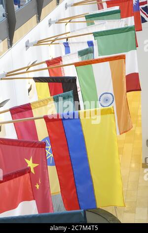 Vertical closeup shot of the flags of different countries on display in a building Stock Photo