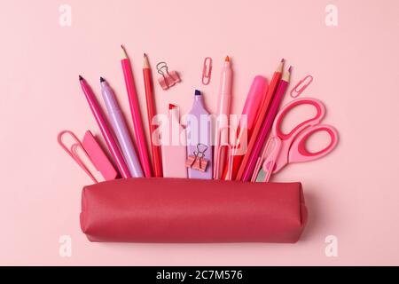 Pink pencil case with different supplies on pink background Stock Photo
