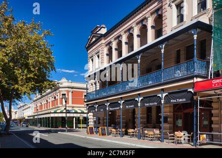 Typical older style buildings with arches and verandas with pretty wrought iron railings on a street in Fremantle, Western Australia. Stock Photo