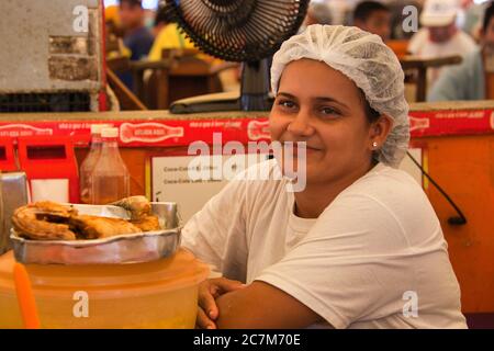 A lady at a food stall stops to look at the camera, in the market at Belem in Para State, Brazil. Stock Photo