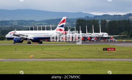 Glasgow, Scotland, UK. 17 July 2020. Pictured:  Grounded British Airways Airbus A319/A320/A321 aircraft form the backdrop showing how bad the coronavirus (COVID19) crisis has affected the global airline industry, as a BA Airbus A320 Neo shuttle service seen departing Glasgow International Airport for London.  British Airways today axed all of its Boeing 747 services cutting back and have already axed a quarter of its staff due to the pandemic. Credit: Colin Fisher/Alamy Live News. Stock Photo