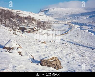 This is Ingleborough mountain in winter  viewed from Crina Bottom hill farm one of the famous Yorkshire Dales Three Peaks of Ingleborough, Whernside and Penyghent around 1980 Stock Photo