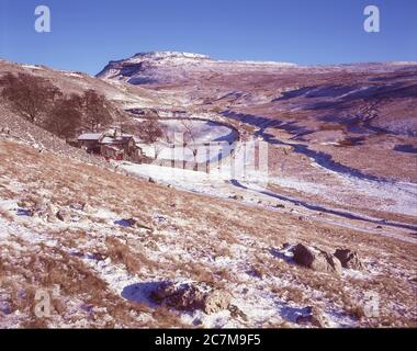 This is Ingleborough mountain in winter  viewed from Crina Bottom hill farm one of the famous Yorkshire Dales Three Peaks of Ingleborough, Whernside and Penyghent around 1980 Stock Photo