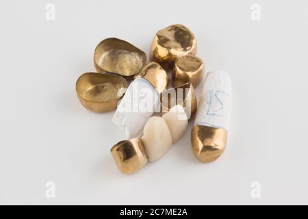 stamped brazed dental bridges covered with gold coated on white background Stock Photo