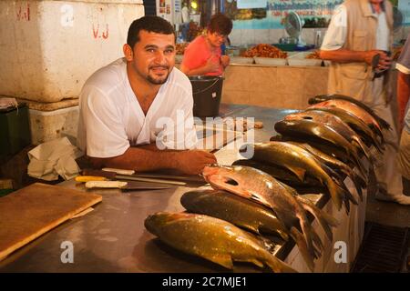 A man at his stall in the market with fresh caught fish, leaning on the counter and looking at the camera, in Manaus, Amazonas State, Brazil Stock Photo