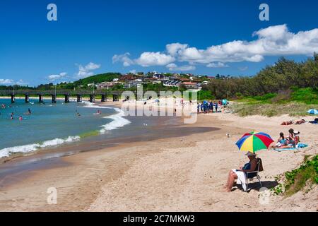 One of the beaches at Coffs Harbour on the mid coast of New South Wales, Australia. Person under a colourful umbrella in the foreground Stock Photo