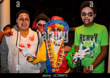 10-31-2017 Tulsa USA Four African American boys in zombie face paint and one dressed like a clown giving two peace signs trick or treat on Halloween Stock Photo