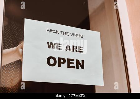 White sign on the cafe window meaning that it is open after quarantine Stock Photo