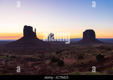 Monument Valley buttes silhouette and horizon view at dark dawn night with sunrise colorful light in Arizona in sky Stock Photo