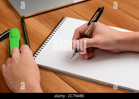 Student writing in the notepad. Making notes and studying Stock Photo
