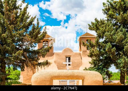 Ranchos de Taos St Francic Saint Francis Plaza and San Francisco de Asis church with cross and gate entrance on sunny day in New Mexico Stock Photo