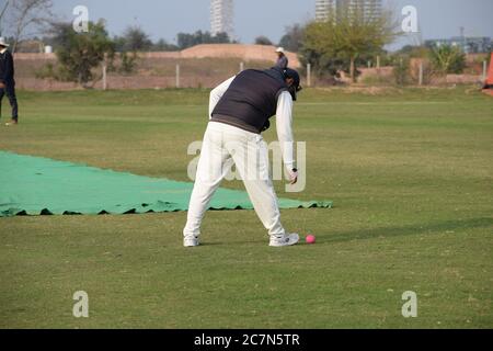 Full length of cricketer playing on field during sunny day, Cricketer on the field in action, Players playing cricket match at field during the day ti Stock Photo