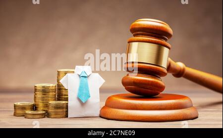 Businessman in shirt and tie with stack of coins and judge gavel on brown background. Concept of business sentence or non-payment of taxes Stock Photo