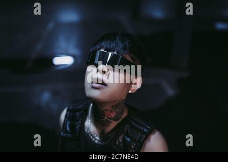 The decline of humanity. A man in cyber glasses looks at the light. Cyberpunk. Stock Photo