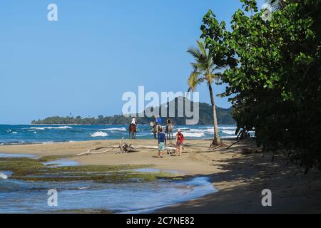 Tourists riding horses on the beach in Puerto Viejo, Costa Rica Stock Photo