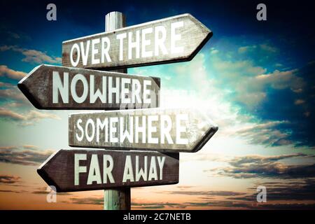 Over there, nowhere, somewhere, far away - wooden signpost, roadsign with four arrows Stock Photo