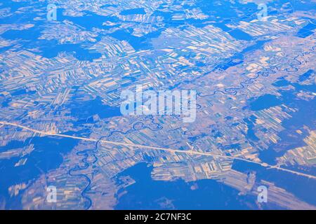 Aerial view of river meander and plains . Panoramic view of river and highway . View from airplane window . Flying over Poland Stock Photo