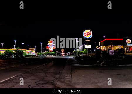 Wendover, USA - July 27, 2019: Nevada city near Utah border with Burger King and famous Rainbow hotel and Casino on road at night illuminated neon lig Stock Photo