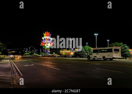 Wendover, USA - July 27, 2019: Nevada city near Utah border with Rainbow Casino on road at night illuminated neon lights and shuttle bus on boulevard Stock Photo