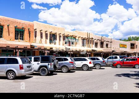 Taos, USA - June 20, 2019: Colorful downtown plaza square in famous town city village with sign on shop exterior and cars parked on sunny day Stock Photo