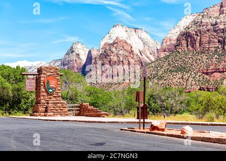 Springdale, USA - August 5, 2019: Zion National Park entrance sign welcome on road in Utah and cliff rock formations Stock Photo