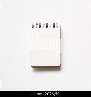 Empty spiral notebook on white painted background. top view, copy space Stock Photo