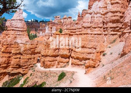 Queen's Garden Navajo Loop trail at Bryce Canyon National Park in Utah on sunny day with footpath hike fence and orange rock Stock Photo