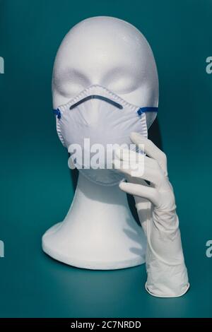 Vertical shot of a white mannequin head wearing a medical face mask - the concept of coronavirus Stock Photo