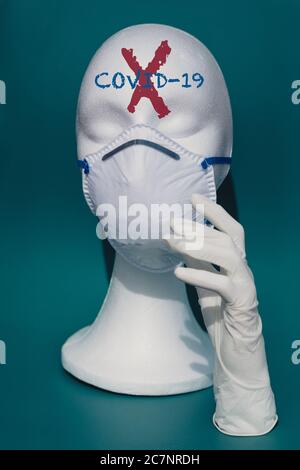 Vertical shot of a white mannequin head wearing a medical face mask - the concept of coronavirus Stock Photo