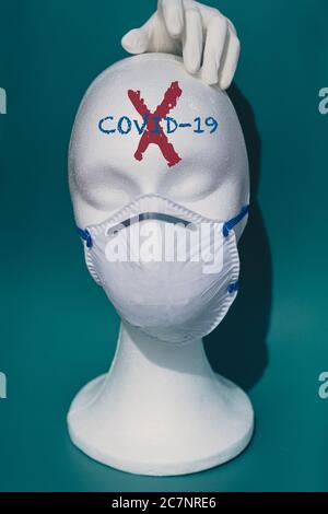 Vertical shot of a white mannequin head wearing a medical face mask - the concept of coronavirus Stock Photo