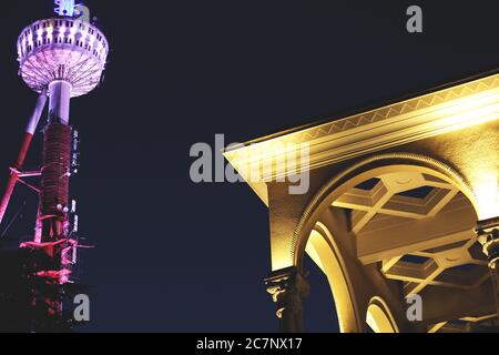 Illuminated telecommunications tower and a building near it at night in Yerevan, Armenia Stock Photo