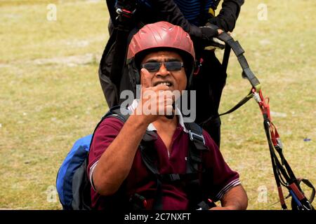 An Indian para glider showing thumps up after landing  in Naukuchia Taal in Nanital, Selective focusing Stock Photo