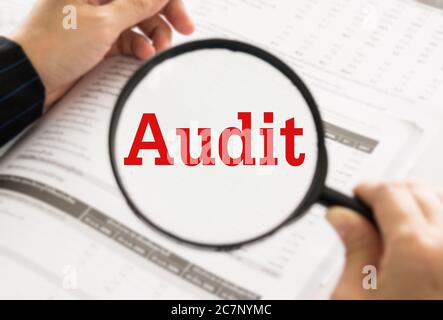 Audit concept.  Auditor or IRS using magnifier auditing revenue in financial statement, auditing tax process. Stock Photo