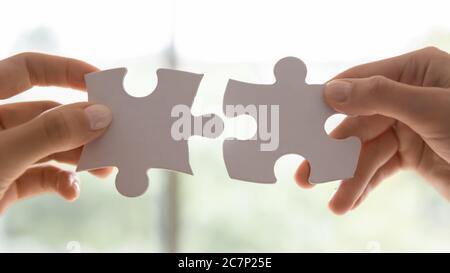 Closeup view women hands holding pieces join puzzles having fun