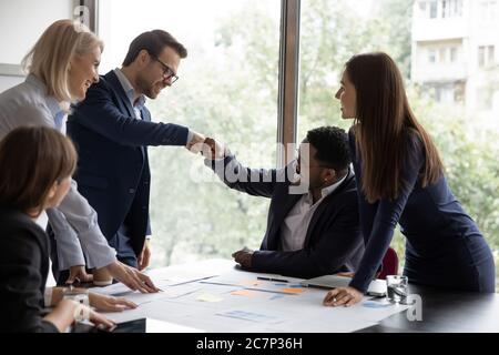 Multiethnic businessmen fists bump celebrating corporate achievements Stock Photo