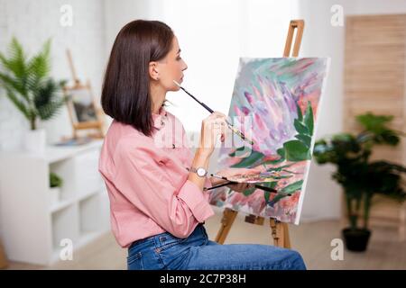 art, creativity and inspiration concept - back view of woman artist painting with acrylic paints Stock Photo