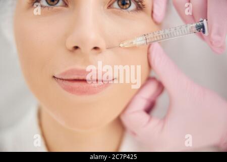 Hands of skilled beauty therapist conducting anti aging procedure