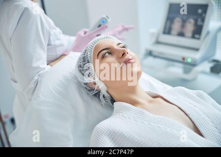 Optimistic lady getting ready for skin lifting procedure Stock Photo