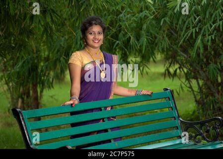 Beautiful Indian young girl in Traditional Saree posing outdoors Stock Photo