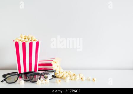 close up of two striped boxes with popcorn, 3d glasses and copy space over white Stock Photo