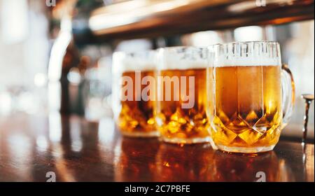 Glasses of light beer on a dark pub. Stock Photo