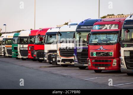 E30 HIGHWAY, GERMANY - JUN 14, 2019: Row of various company trucks parked at a truck overnight parking somwehere along the E30 highway in Germany. Stock Photo