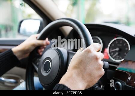 Close up of man hands driving a car during sunlight. Vintage filter Stock Photo