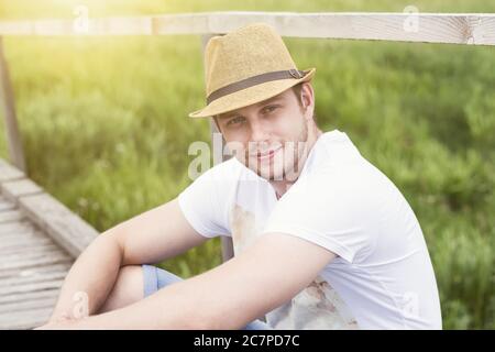 Close up portrait of smiling handsome man sitting outdoor Stock Photo