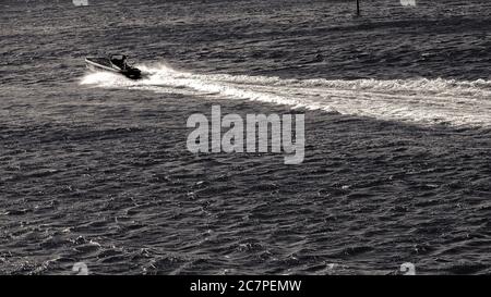 Grayscale shot of a sailing boat on the sea during a bright day Stock Photo
