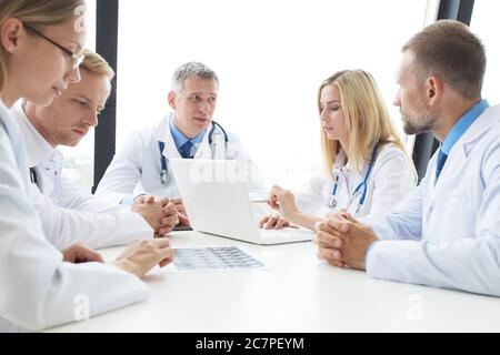 Team of experts doctors examining mri report on hospital office meeting Stock Photo
