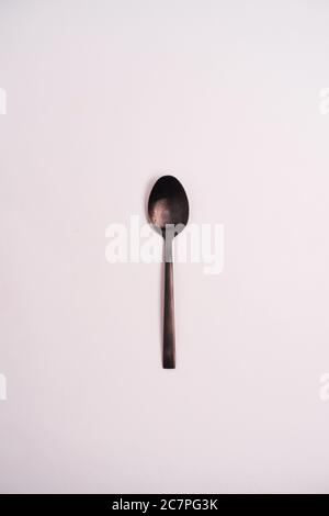 Closeup shot of a metal teaspoon isolated on a light-colored background Stock Photo