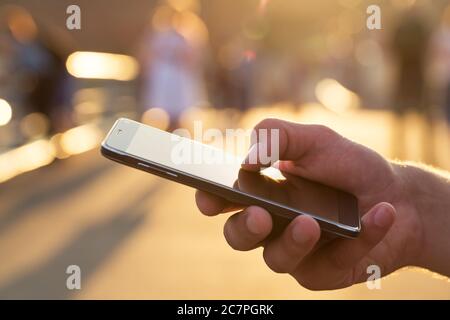 Man using his Mobile Phone outdoor, close up Stock Photo