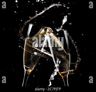 Clinking glasses of champagne with splash on dark background Stock Photo