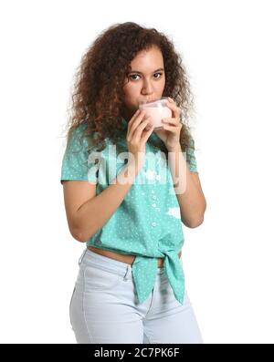 Young woman in dirty clothes drinking tasty yogurt on white background Stock Photo